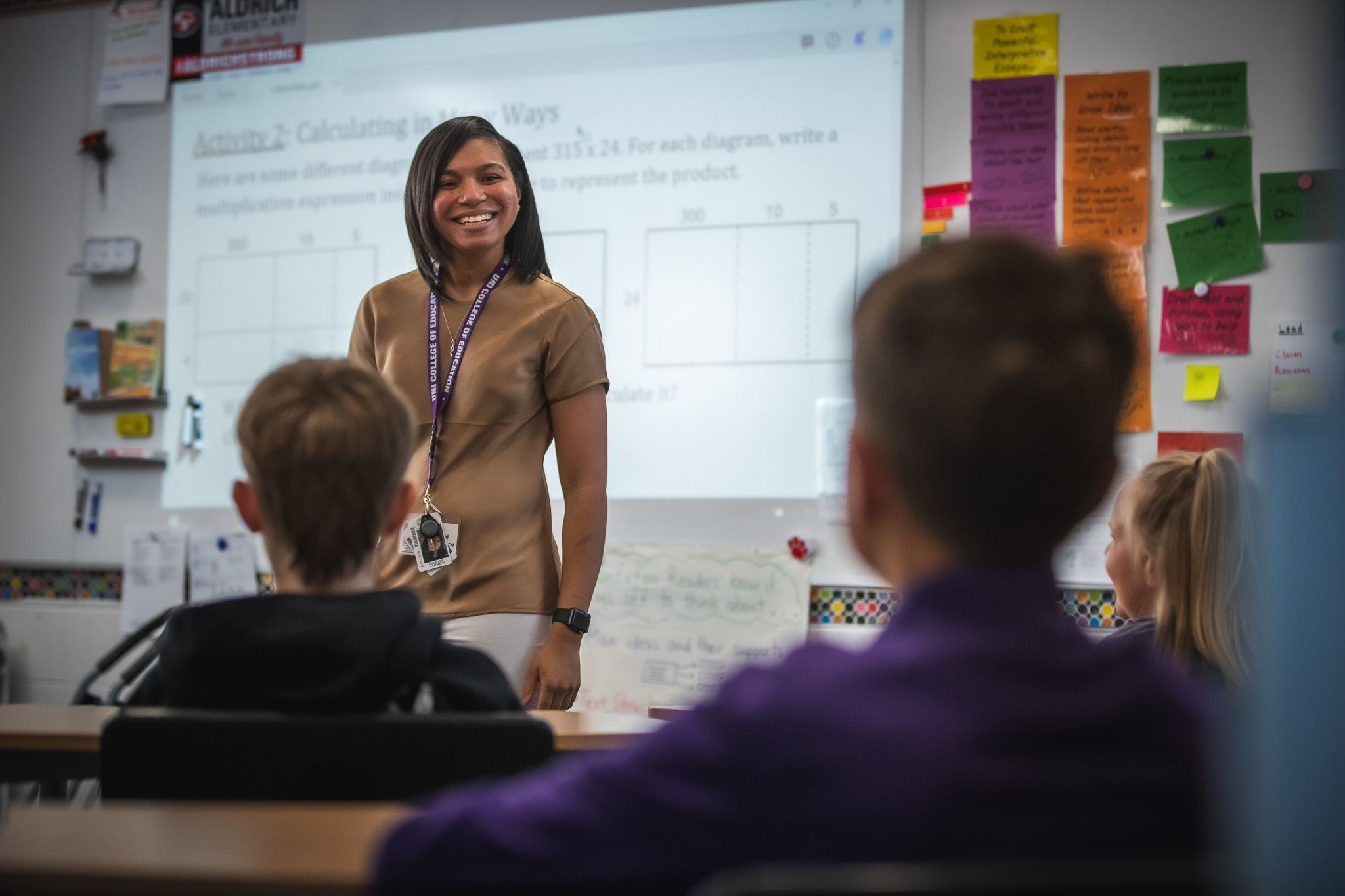 Elementary Education student smiling in front of a classroom