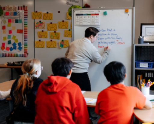 Teacher at the white board teaching students.