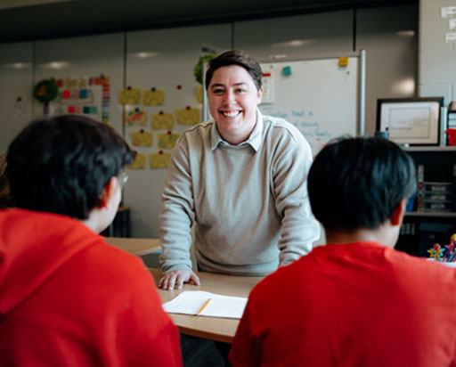 Instructor standing in a classroom in front of students.
