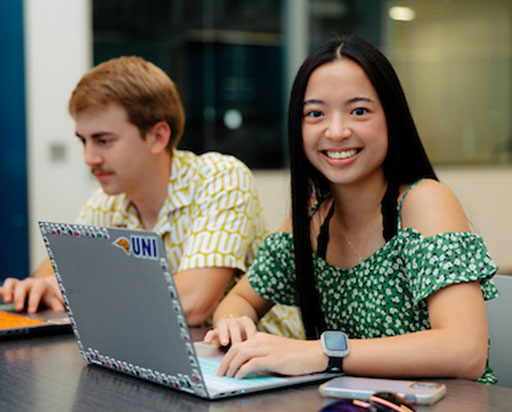 student working a computer smiling