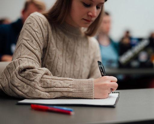 student writing in a notebook
