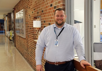 Principal standing in school hallway