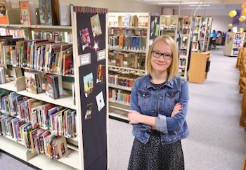 Librarian standing among the stacks in a library