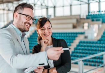 Two people talking in a sports arena