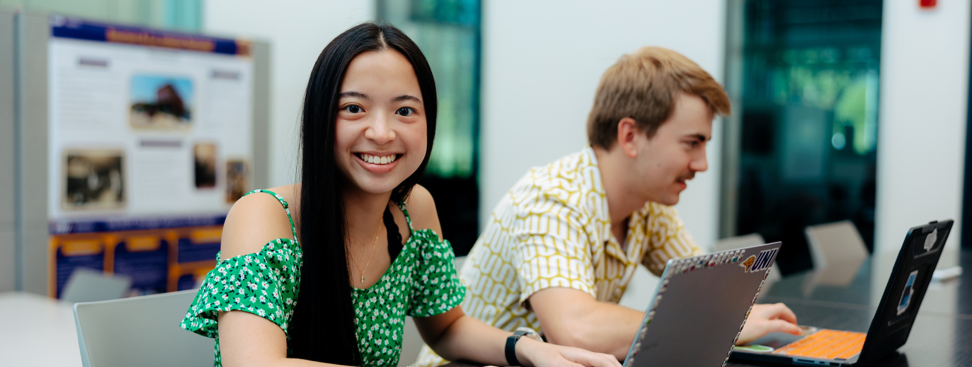 Students in front of laptops in a building on campus