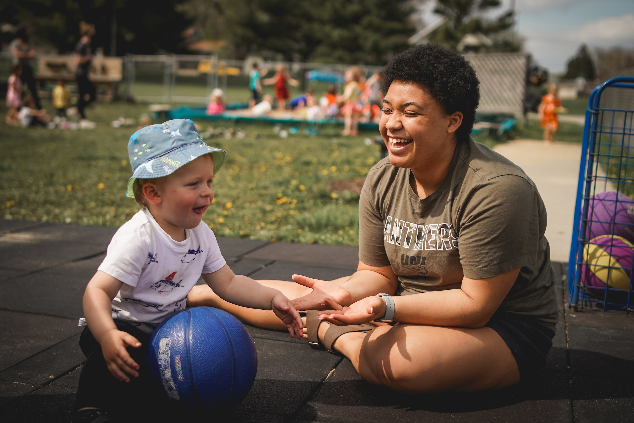 Teacher with young student on the playground.