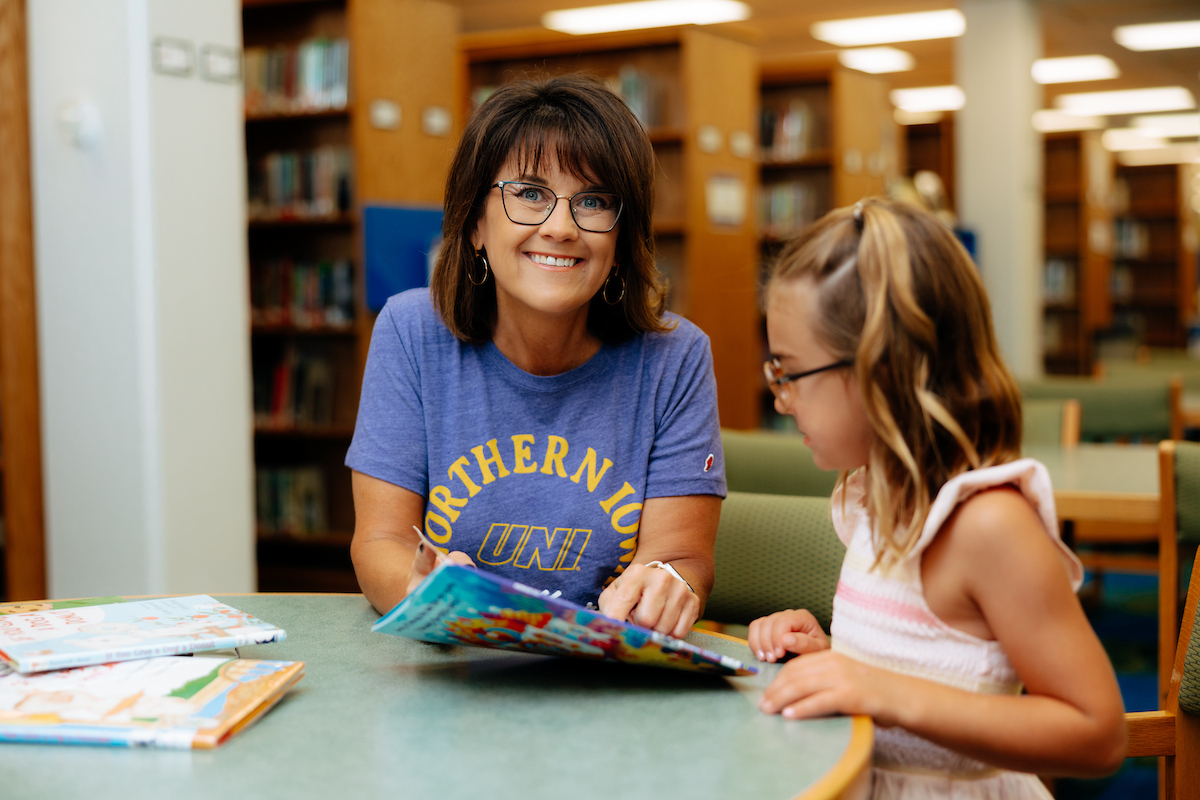 UNI Alumni Librarian reading with child 