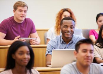 college students sitting in a lecture hall smiling