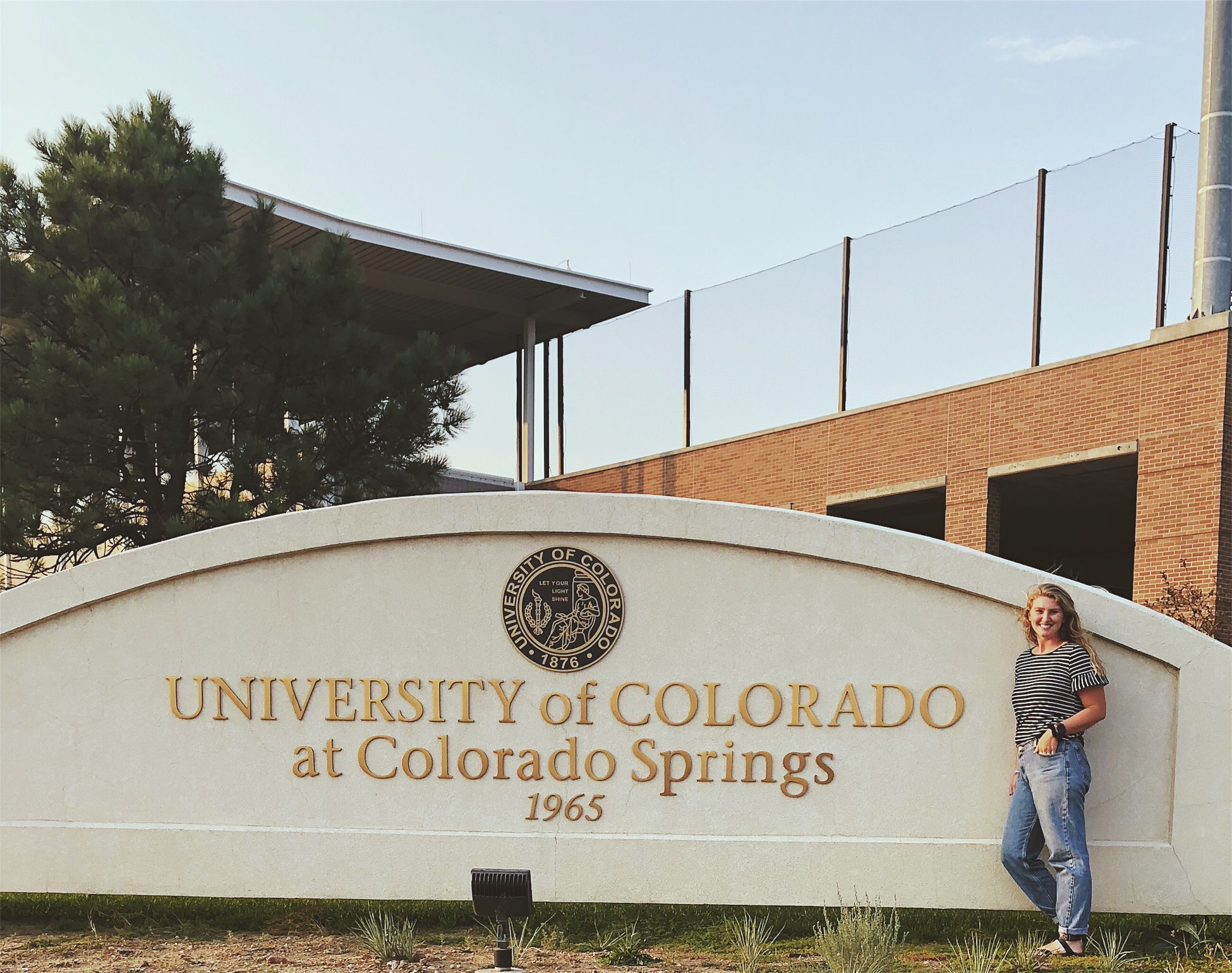 NSE student standing next to University of Coloardo at Colorado Springs sign