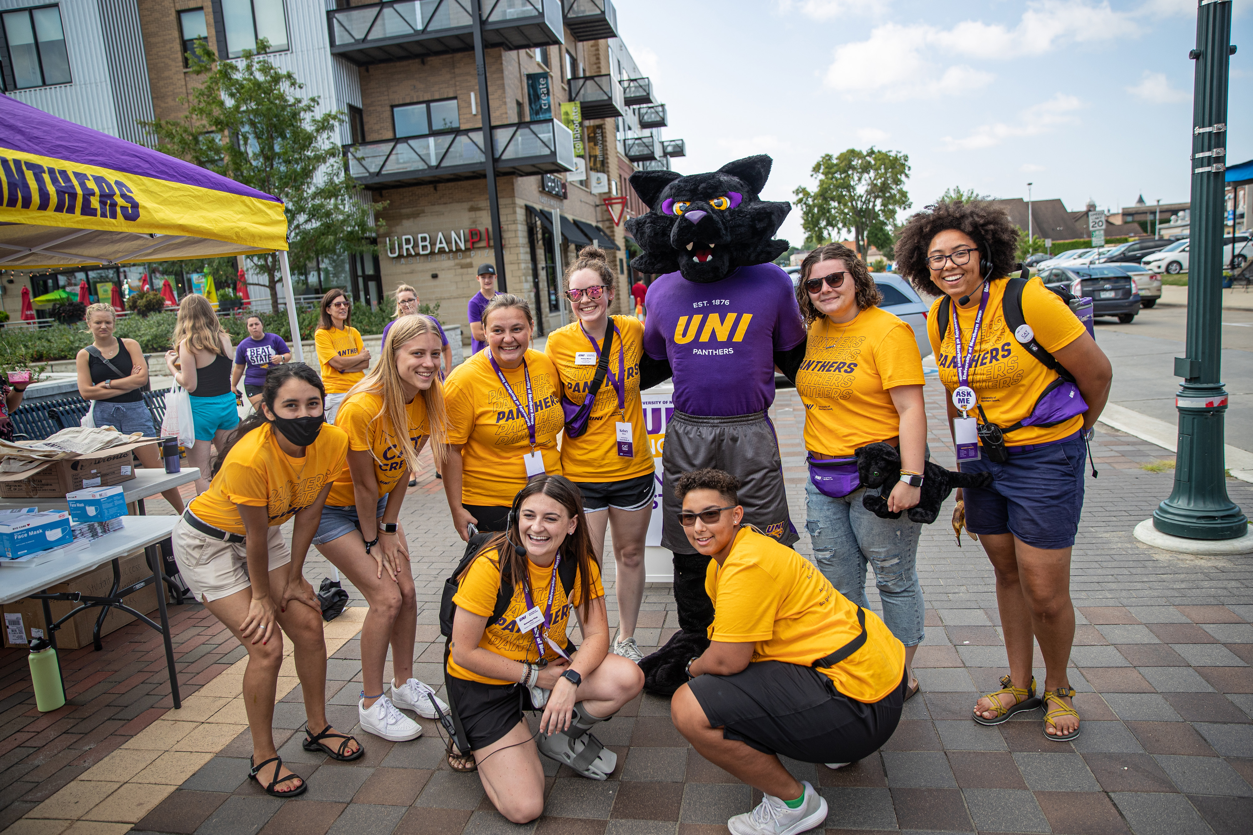 Smiling UNI students posing for a photo in downtown Cedar Falls