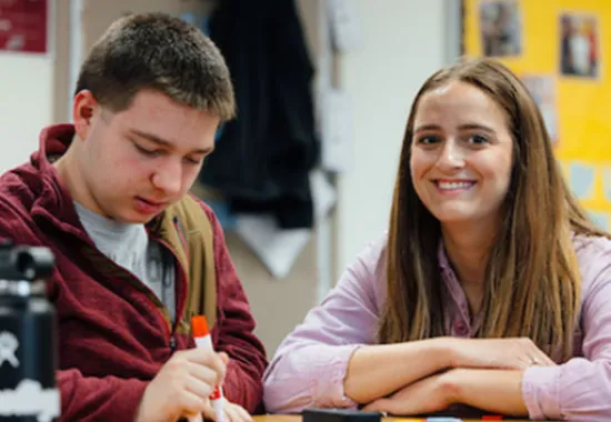 Two students sitting at a desk working on an assignment.