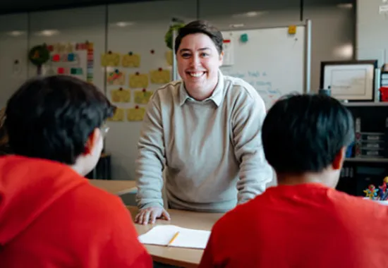 Instructor standing in a classroom in front of students.