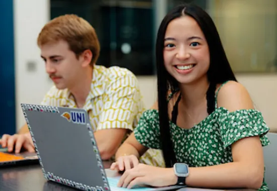 student working a computer smiling