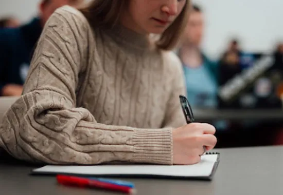 student writing in a notebook