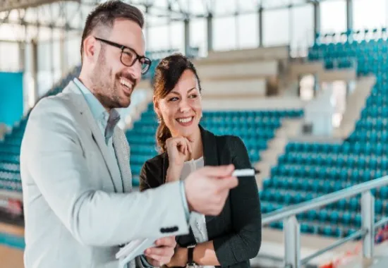 Two people standing in a stadium.