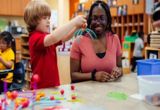 Teacher and student playing with building toys.