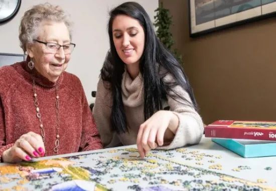 Two women doing a puzzle together.