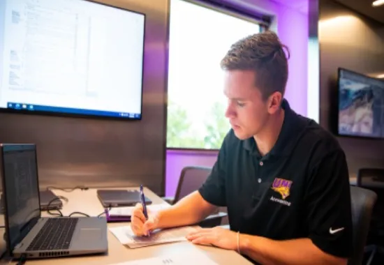 Man working on paperwork by laptop.