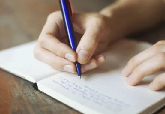 student writing in a notebook