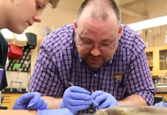 Science teacher showing a student a dissection.
