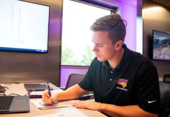 Man working on paperwork by laptop.